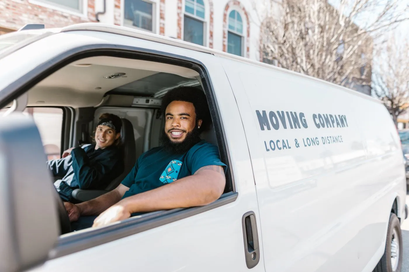 Equipe da JKL Transportes ao lado do veículo de mudança